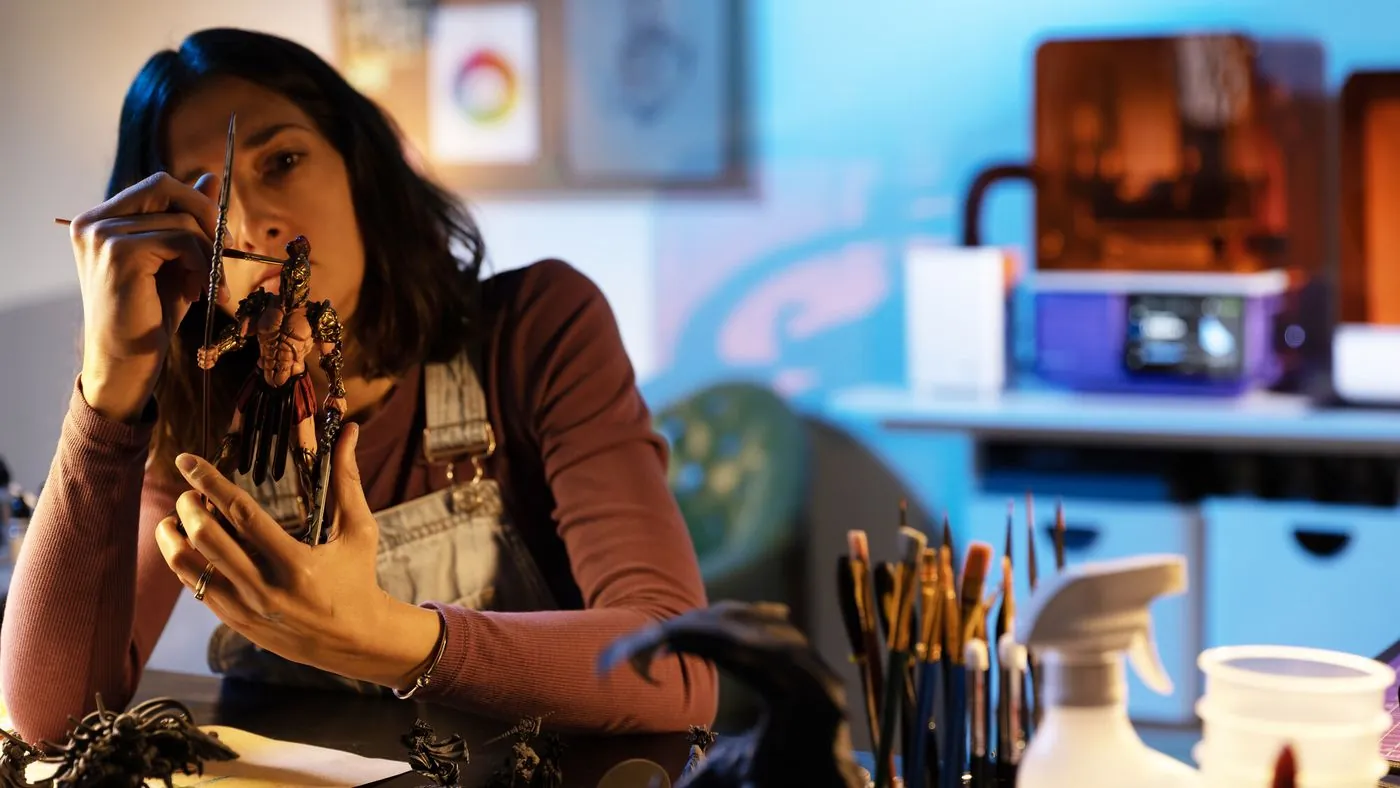 Artista pintando una miniatura impresa en resina